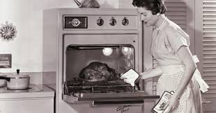 Dona de casa usando um forno de micro-ondas dos anos 1950